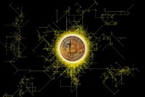 A close-up of a physical Bitcoin placed on top of a circuit board, symbolising the connection between cryptocurrency and blockchain technology.